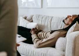 Man laying on a couch talking to a therapist