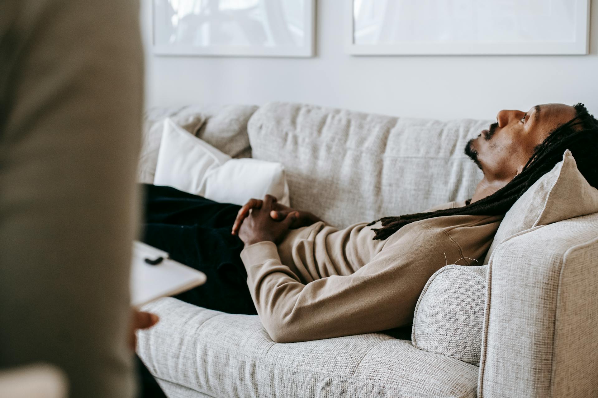 Man laying on a couch talking to a therapist