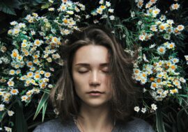 Person asleep in the middle of white daisies