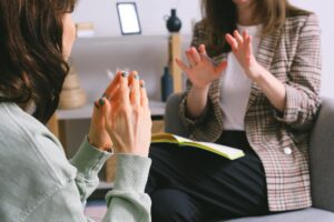 Therapy session with female client and female therapist making hand gestures